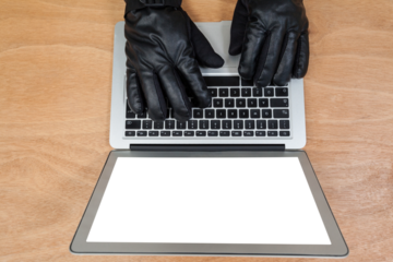Cropped hands of hacker using laptop