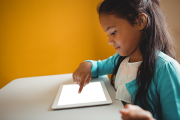 Girl using digital tablet on desk