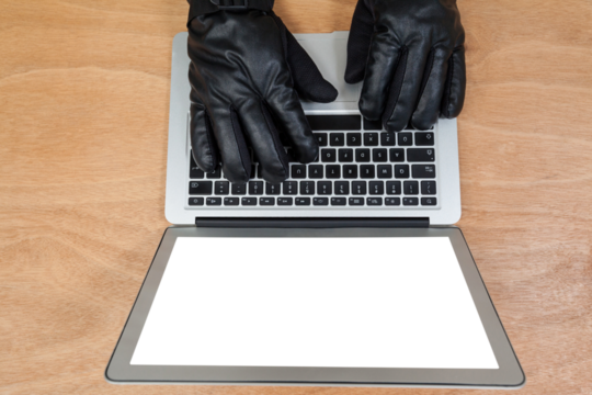 Cropped hands of hacker using laptop - Powered by Adobe