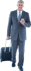 Businessman walking with luggage and using his smartphone
