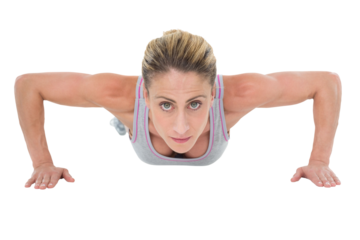 Strong woman doing press ups looking at camera