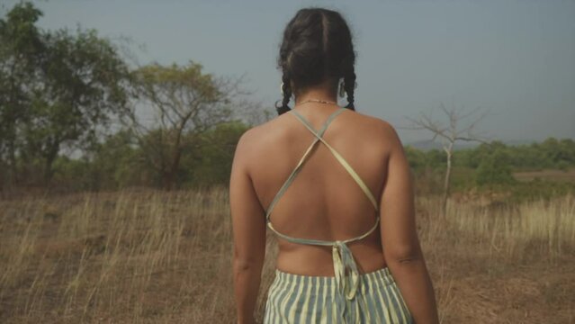 Fashionable Indian Woman with Ponytails Walks in nature, Close up, From Behind