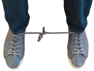 Man with shoelaces tied together