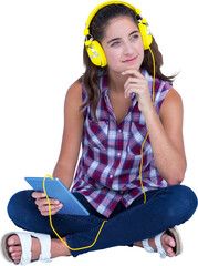  Woman listening music through headphones while holding digital tablet