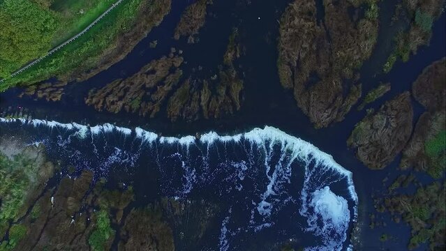 Straight down aerial view of Venta Rapid - ascending reveal of the widest waterfall