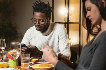 Fototapeta na wymiar Interracial Couple Experiencing Phubbing at Restaurant