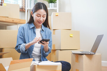 Small business entrepreneur SME, asian young woman owner checking order with laptop computer, using...