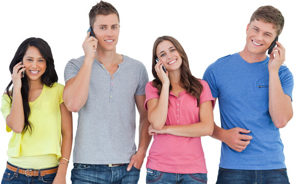 A smiling group of friends make calls while looking into the camera