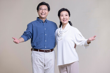 Studio shot of cheerful senior Chinese couple