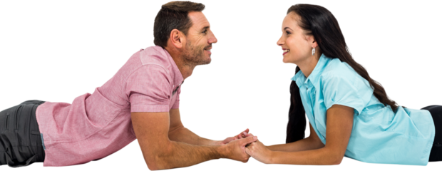 Smiling couple laying on the floor face to face holding hands