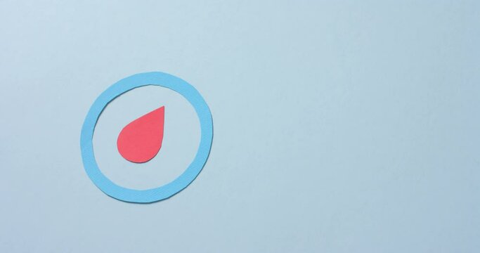 Close up of blood drop in blue circle on blue background, copy space, slow motion