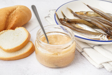 Jar with delicious caviar of capelin, baguette and smoked fish on white background