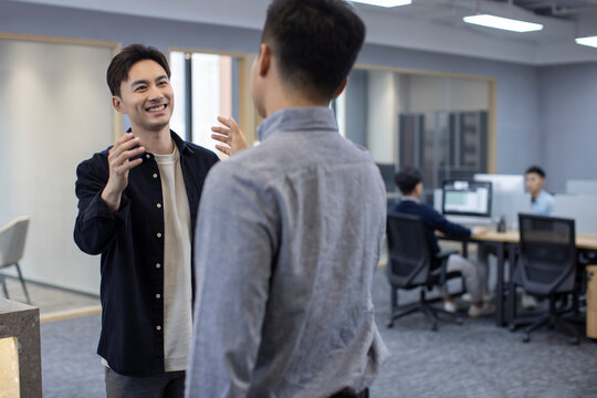 Cheerful Chinese business people greeting in office