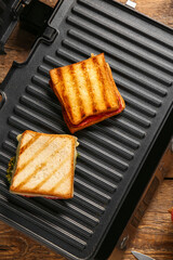 Delicious sandwiches on modern electric grill, closeup