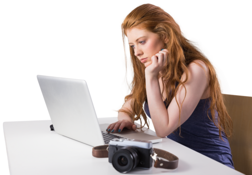 Pretty redhead working on laptop