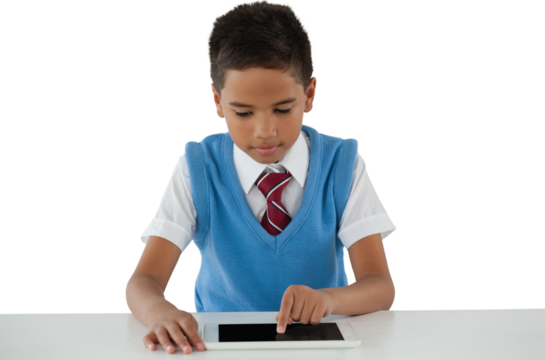Schoolboy using digital tablet at table