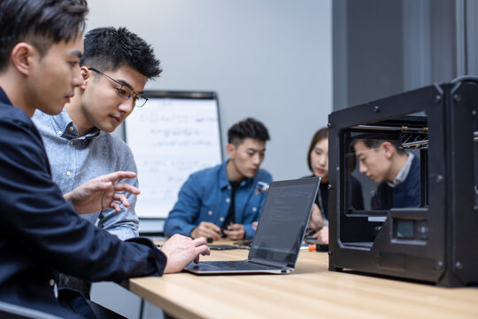 Confident Chinese designers using a 3D printer