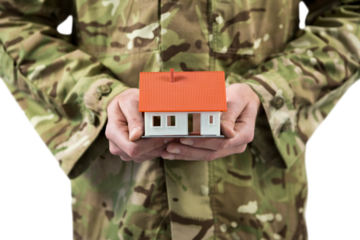 Mid section of soldier holding model home