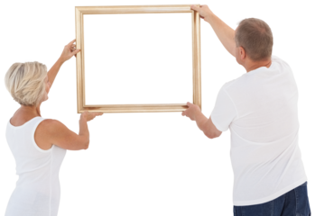 Mature couple hanging up picture frame
