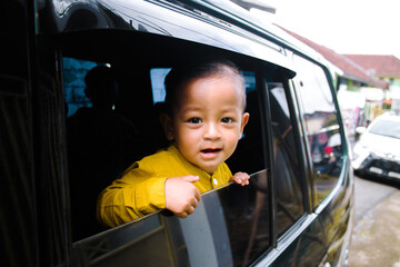 Smiling little boy in car window
