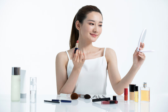 Beautiful young Chinese woman applying makeup