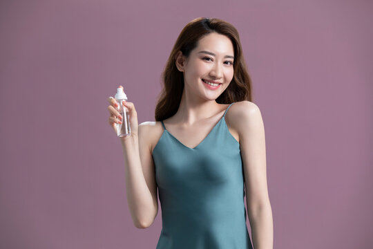 Beautiful young Chinese woman with spray bottle