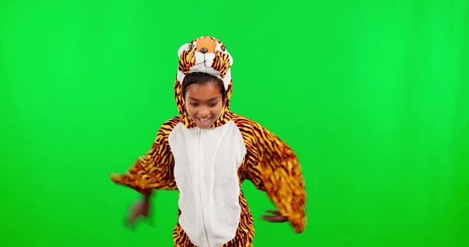 Costume, dance and face of a girl on a green screen isolated on a studio background. Fun, playful and portrait of a child dressed as a tiger dancing and being funny on a backdrop with mockup