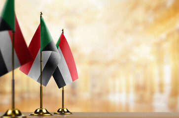 Small flags of the Sudan on an abstract blurry background