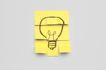 Sticky papers with drawn light bulb on light background. Insight concept