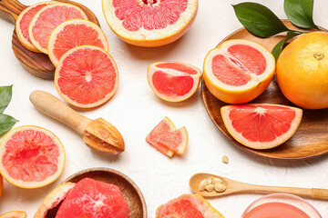 Fototapeta na wymiar Composition with cut ripe grapefruits on light background