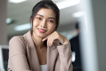 Portrait young asian businesswoman looking at the camera standing in modern office.
