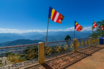 Colourful Buddhist Prayer flags are waving in strong wind under sunshine at Samdruptse, huge...