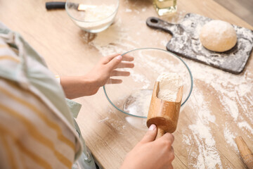 Fototapeta na wymiar Woman making dough for pasta at table in kitchen, closeup