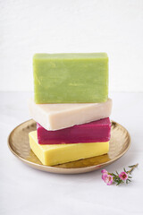 Plate with stack on natural soap bars on light background