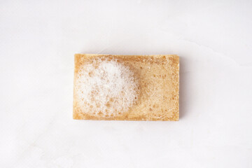 Natural soap bar with foam on light background