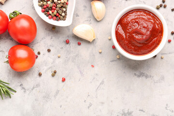 Composition with bowl of tasty tomato paste and spices on white grunge background