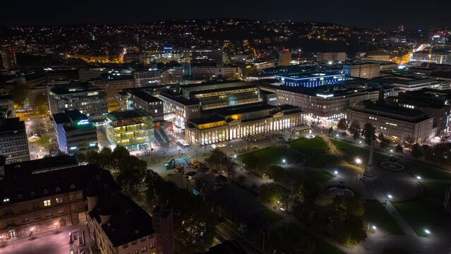 night illumination flight over stuttgart city crowded central street famous park square aerial panorama 4k timelapse germany