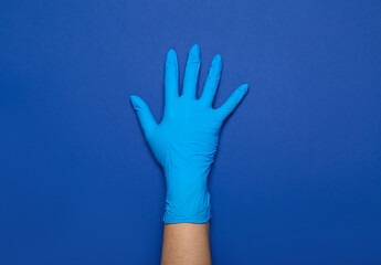 Woman in medical glove on blue background