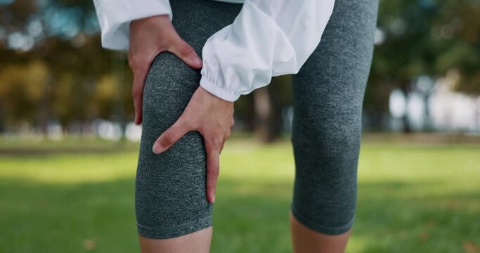 Knee pain, injury and hands of woman in a park for fitness, running and exercise while suffering from arthritis. Injured, leg and girl runner training in nature with ache or muscle, problem or issue