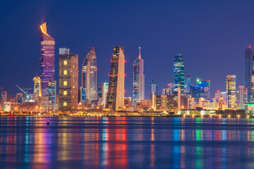 Fototapeta na wymiar Kuwait Skyline view from beach during the national day celebration. Kuwait National day lights on the building and Kuwait flag lights during the night time. Kuwait City skyline view....