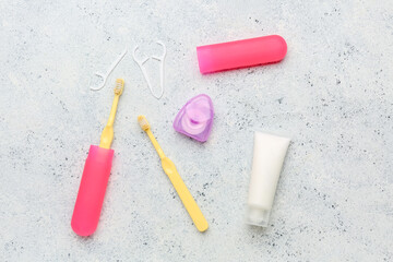 Dental floss, toothpicks, brushes and tube of toothpaste on white grunge background