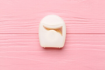 Case with dental floss on pink wooden background