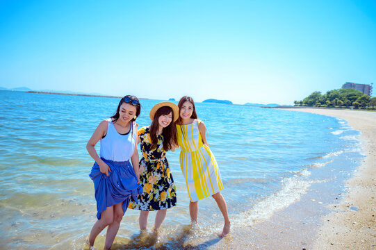 海岸で遊ぶ海のリゾートへ旅する女性3人