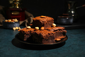 Plate with pieces of tasty chocolate brownie on black background