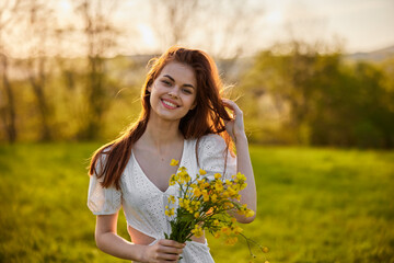 Naklejka na ściany i meble portrait of a happy woman with a bouquet of yellow flowers illuminated from the back by the setting sun