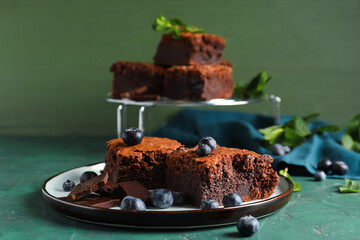 Plate with pieces of tasty chocolate brownie on table