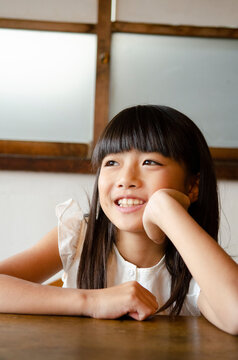 頬杖をついて笑っている女の子