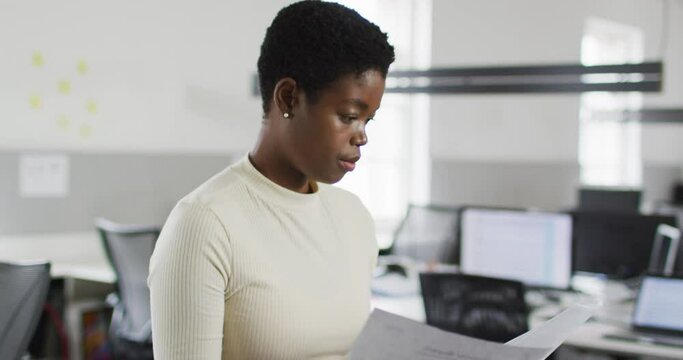 Focused african american businesswoman checking documents in office