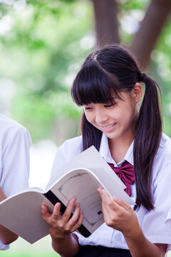 屋外でノートを読む中学生