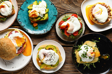 Plates with tasty eggs Benedict on wooden background